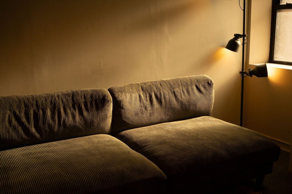 A living room lit by layered wall and table light in the evening