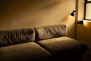 A living room lit by layered wall and table light in the evening